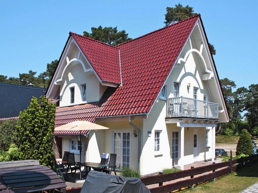 a large white house with a red roof at Doppelhaushälfte Bernsteinhaus II, Trassenheide in Trassenheide