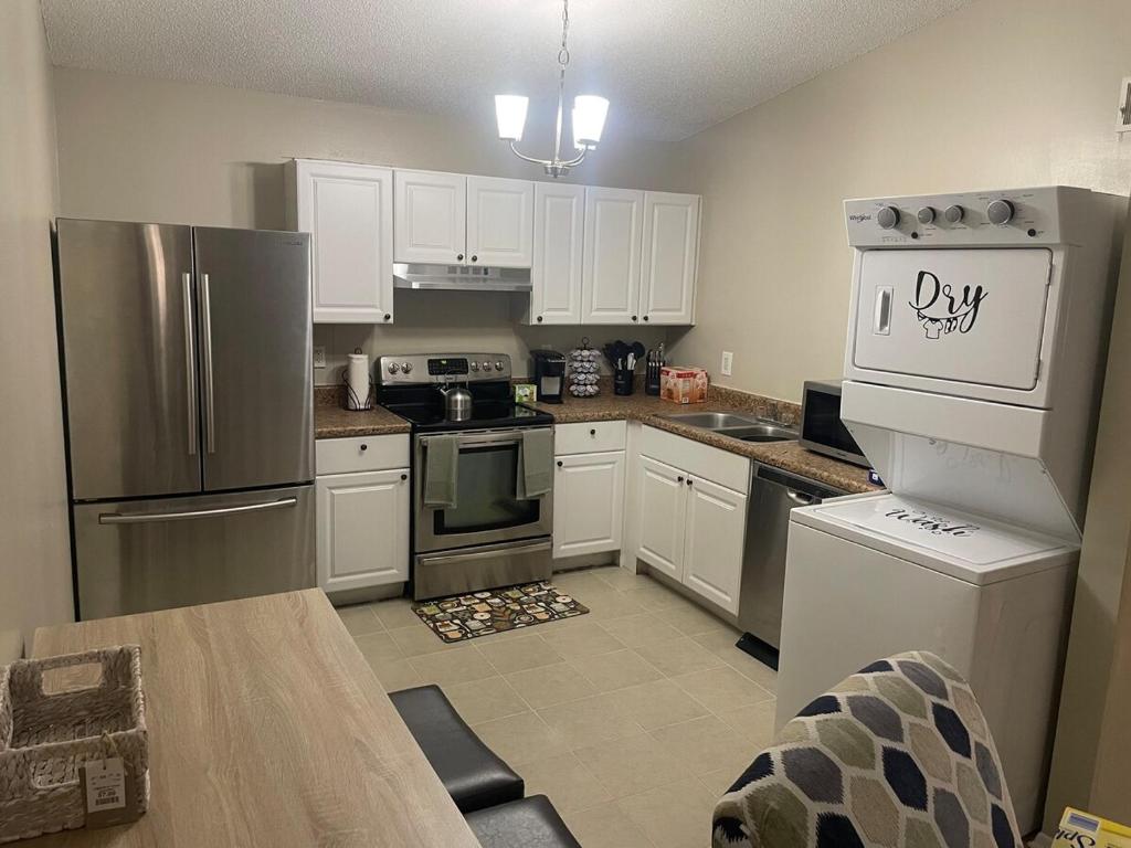a kitchen with white cabinets and stainless steel appliances at 22 min to Beach-2 bd room-Self check in -sleep 6-BBQ-WD in Pensacola