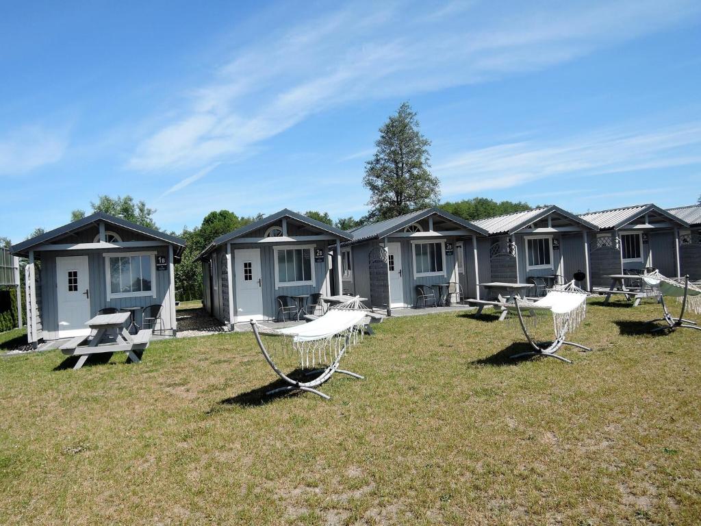 a row of cottages with chairs in the grass at Dziwnówek Holiday House near Beach in Dziwnówek