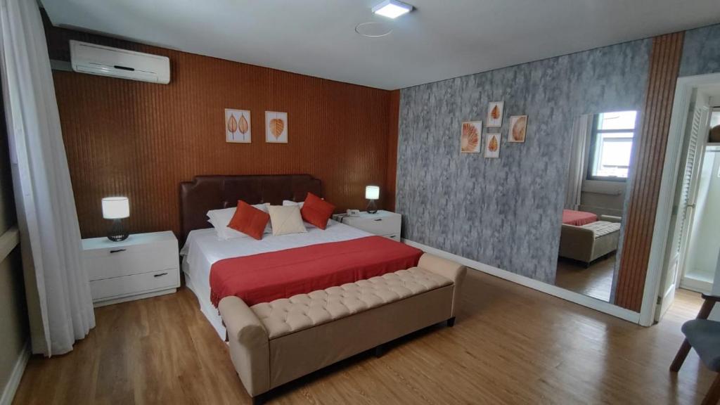 een slaapkamer met een groot bed en een spiegel bij Embaixador Hotel & Centro de Eventos by Fast10 in Porto Alegre