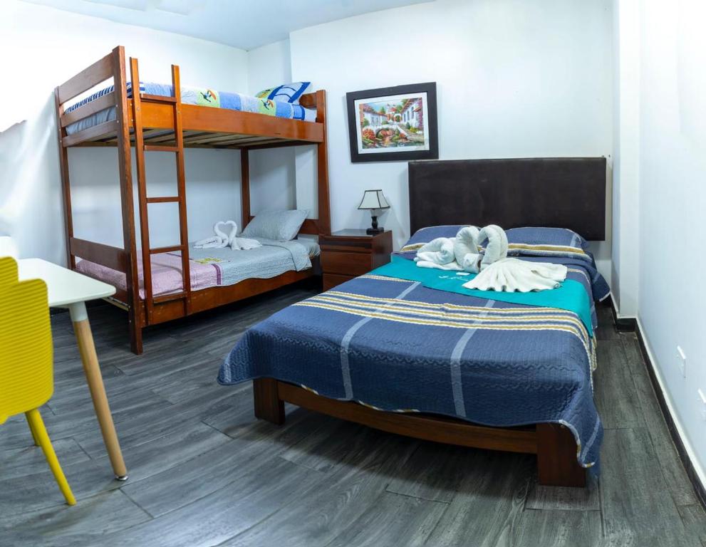 a bedroom with two beds and a bunk bed at Hotel RUAH TUMBES in San Antonio