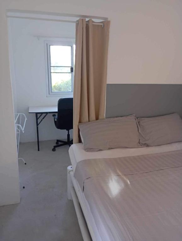 a bedroom with a bed and a desk with a window at Les Twins in Hinkong