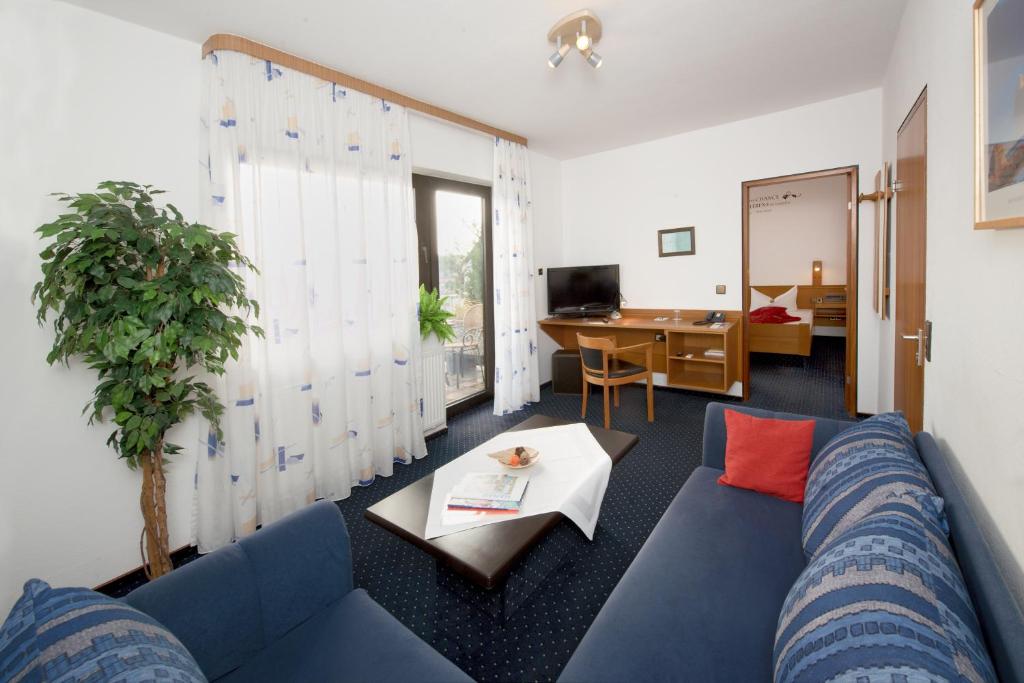 a living room with a blue couch and a table at City Hotel Hanau in Hanau am Main
