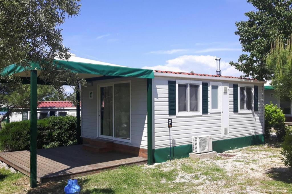 ツレスにあるMobile Home in Cres by Pebble Beach & Marinaの緑日よけ付小白家