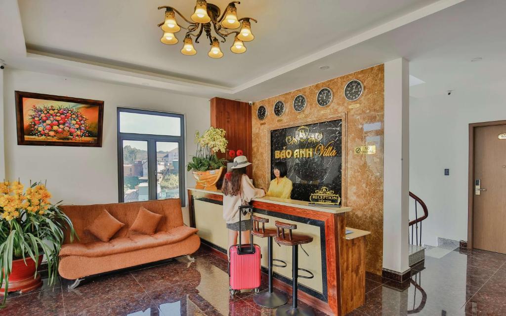 a woman standing at a bar with her luggage at Bảo Anh Villa Đà Lạt in Da Lat
