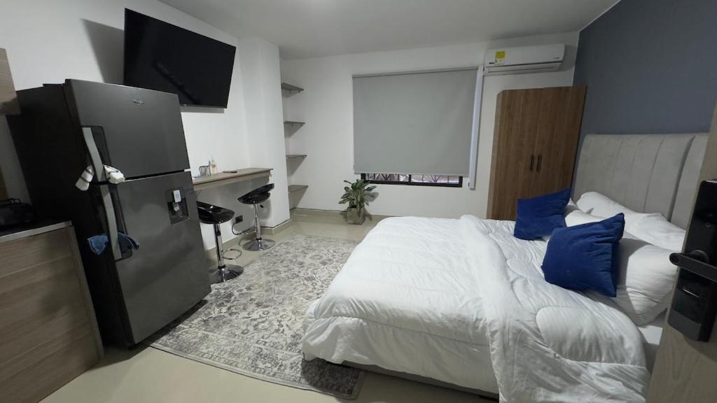 カリにあるVenezia 202のベッドルーム(青い枕とテレビ付)