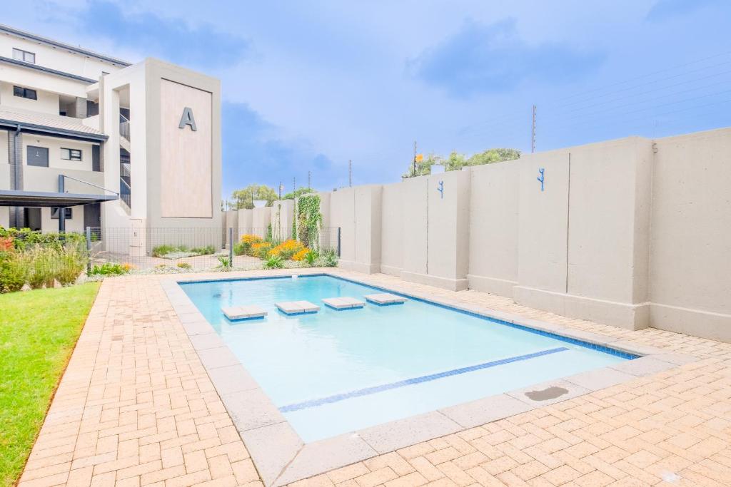 una piscina en el patio trasero de una casa en SoftPod Loft in Prime Location Fourways, en Sandton
