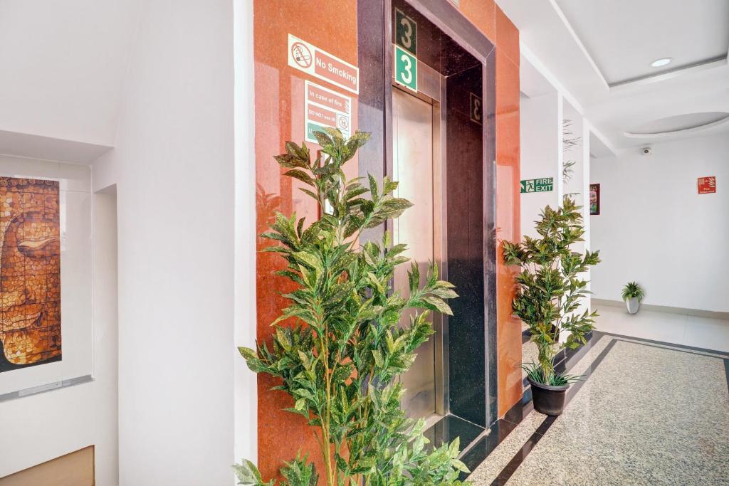 a corridor in a building with potted plants at Super Townhouse RCC PARK VIEW INN in Hyderabad