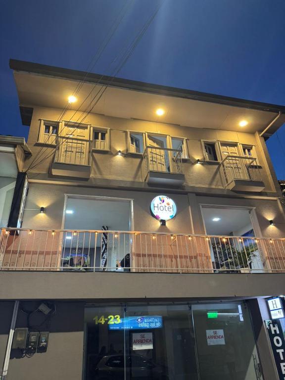 a building with a balcony and a sign on it at Hotel Las Flores in Santa Rosa de Cabal