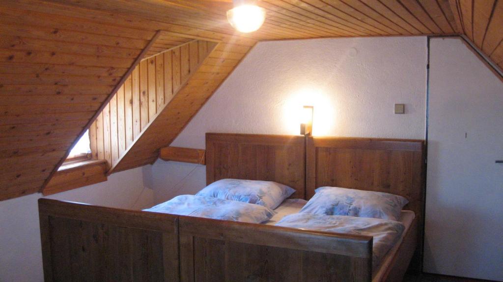 a bedroom with a wooden bed with a staircase at Chalupa Pribylina in Pribylina