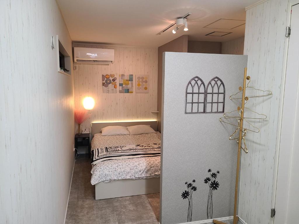 a small bedroom with a bed and a window at Greci Art Tokyo-Kinshicho Area Private room- in Tokyo