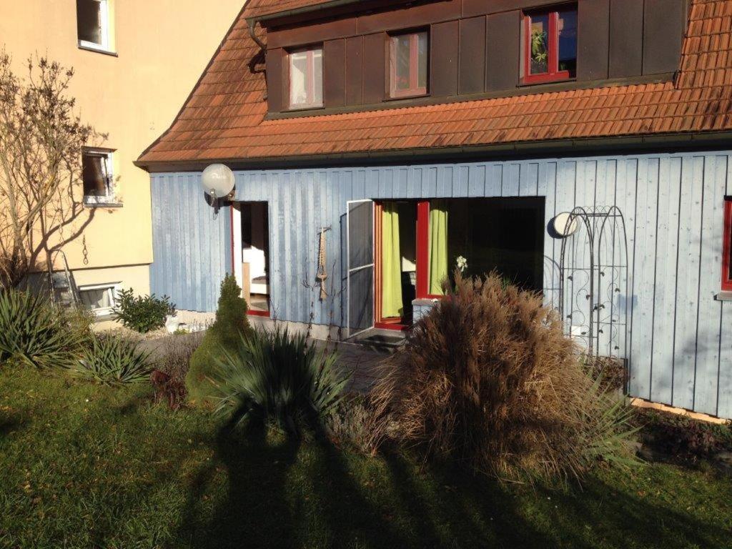 ein blaues Gebäude mit einer offenen Tür im Hof in der Unterkunft Haus Kunterbunt in Reichenberg