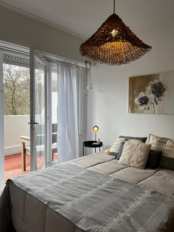 een slaapkamer met een groot bed en een kroonluchter bij Alfonsina Departamento cerca del mar in Mar del Plata