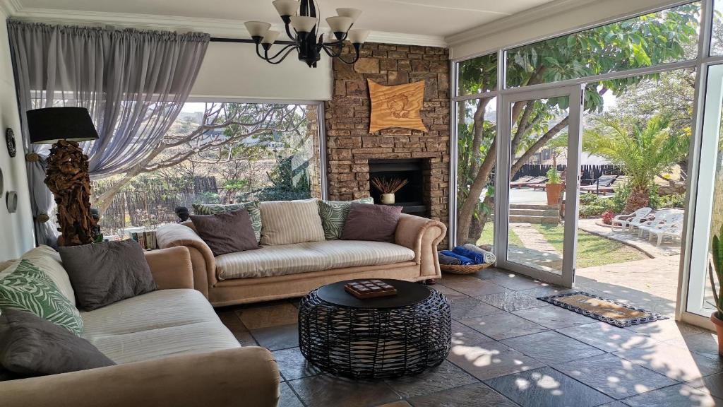 a living room with two couches and a fireplace at Guesthouse Terra Africa in Windhoek