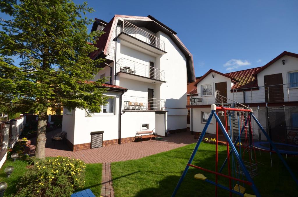 a house with a playground in the yard at Dom Wczasowy ISABELLE in Darlowko