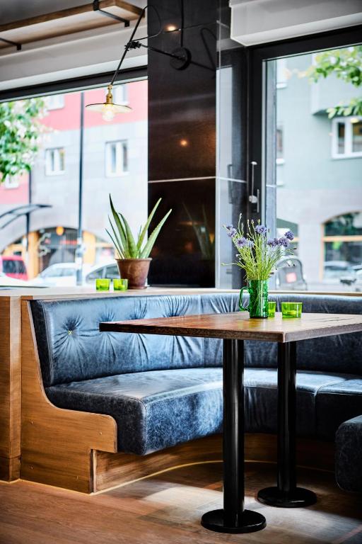 a table and a bench in a room with a window at Generator Stockholm in Stockholm