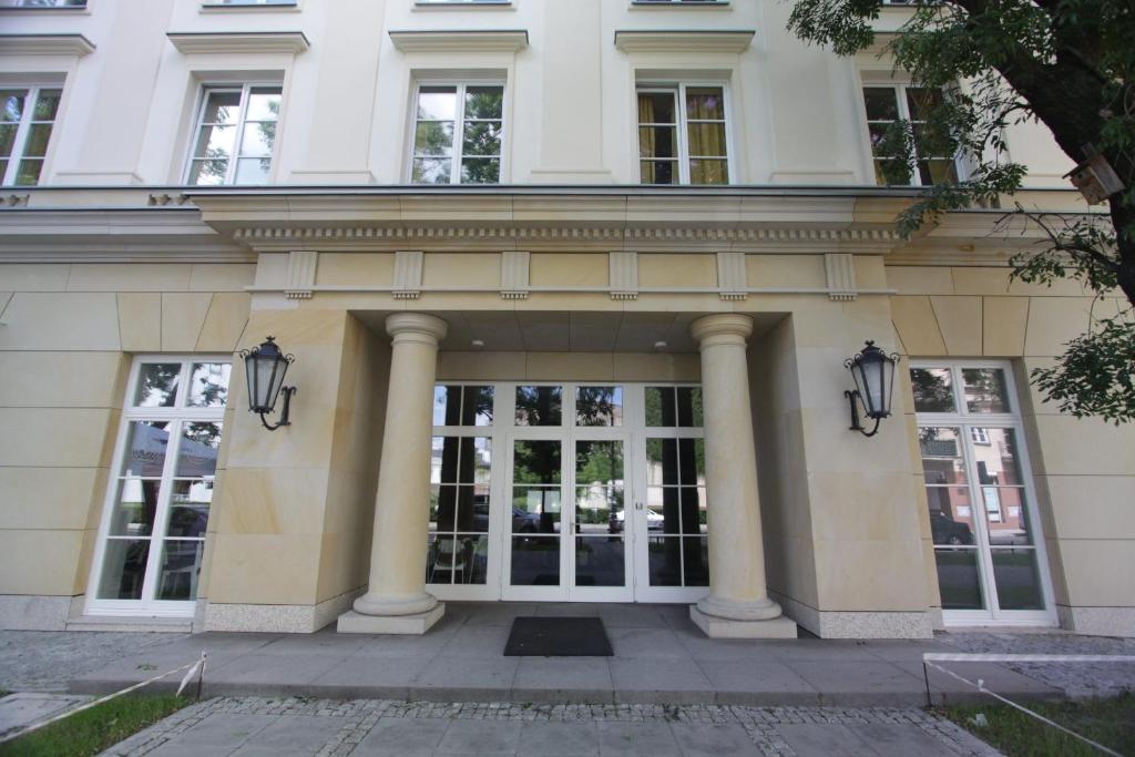 ワルシャワにあるAkademik Praskiの柱と窓のある白い大きな建物