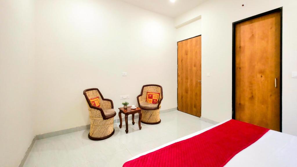 ウダイプールにあるGAJ VILLA Home Stayの2つのバスケットと赤いラグのある寝室