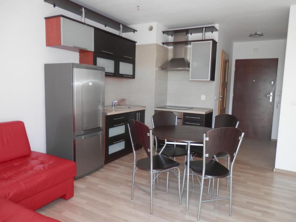 コウォブジェクにあるApartamenty Iz-Mir 2のキッチン(テーブル、椅子、赤いソファ付)
