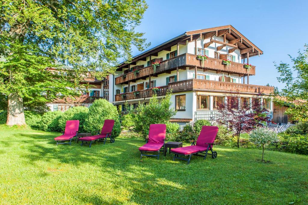 un grupo de sillas rojas frente a un edificio en Gästehaus Linsinger, en Bad Wiessee