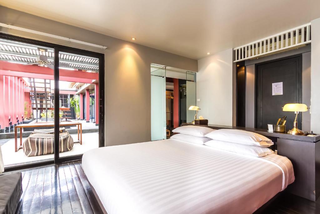 Un dormitorio con una gran cama blanca y una ventana en Loogchoob Homestay en Bangkok