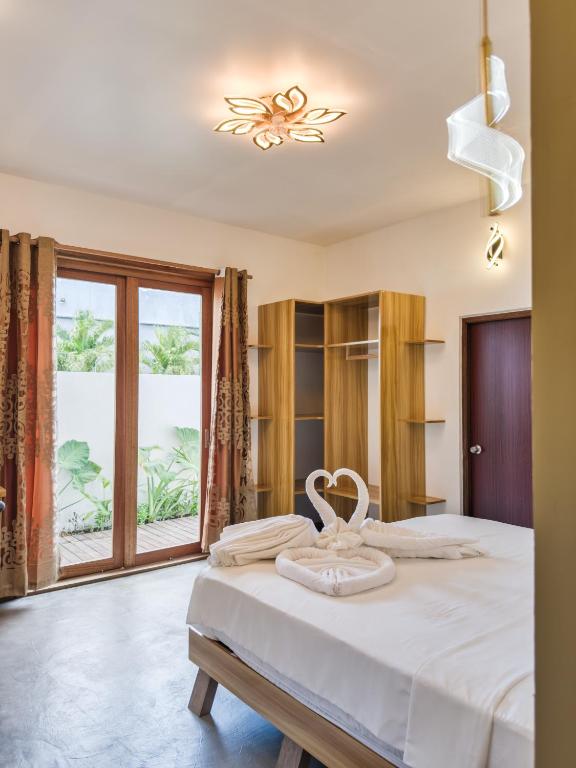 a bedroom with a large bed and a large window at Thundi Villa in Maalhos