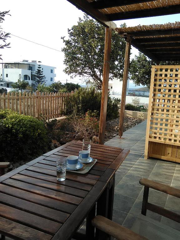 a wooden table with cups and drinks on a patio at Daira Apartments in Diakofti