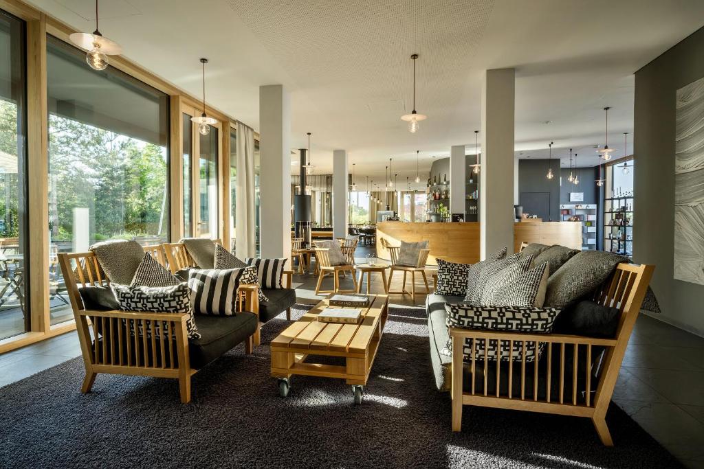a living room with couches and chairs and a table at Bader Hotel in Parsdorf