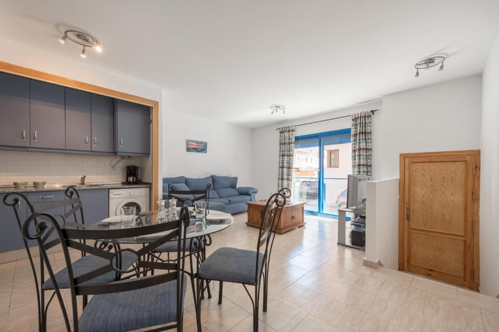 cocina y sala de estar con mesa y sillas en Apartamento Castillejos, en Tarifa