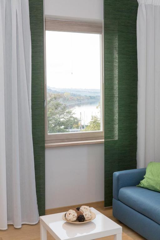 salon z niebieską kanapą i oknem w obiekcie La Suite Sul Lago w mieście Capodimonte