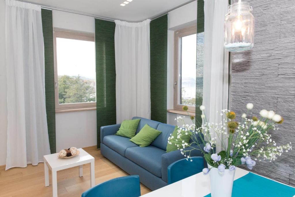 salon z niebieską kanapą i stołem w obiekcie La Suite Sul Lago w mieście Capodimonte
