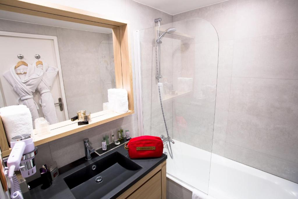 a bathroom with a sink and a glass shower at Cristal Hôtel & Spa in Cannes