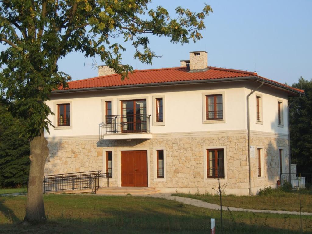uma grande casa de pedra com um telhado vermelho em Winnica Avra em Wola