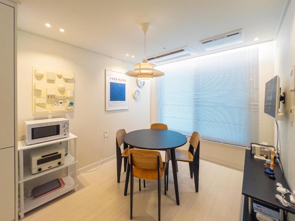 a dining room with a table and chairs at Stay in Seoul, 3 min to Seoul Station, New Apt, 3 Air Conditioners, Elevator, Rooftop, Quiet & Cozy in Seoul