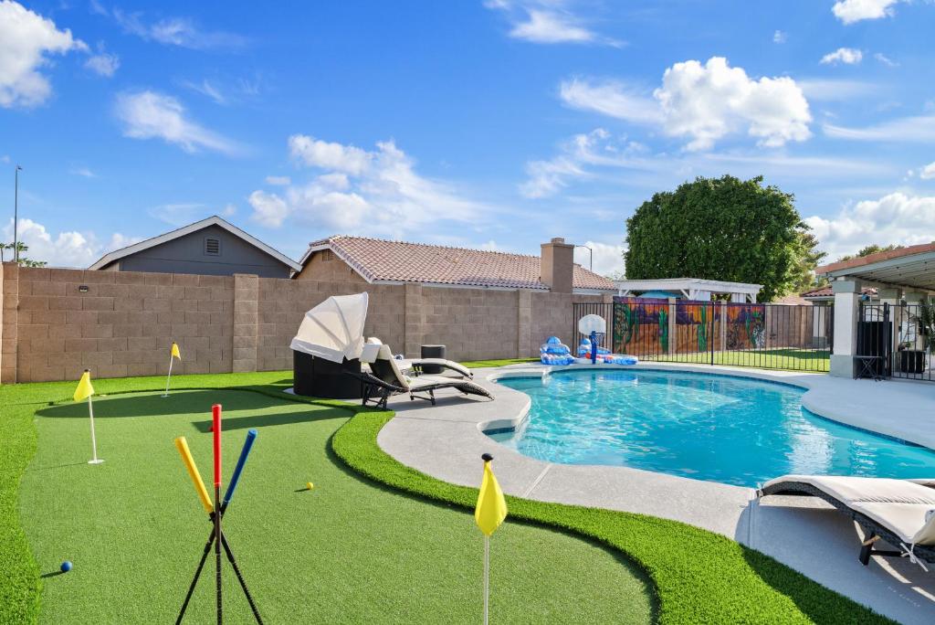 a backyard with a swimming pool with a grassy yard at Summer Splash Pool, Spa & Game Room in Mesa
