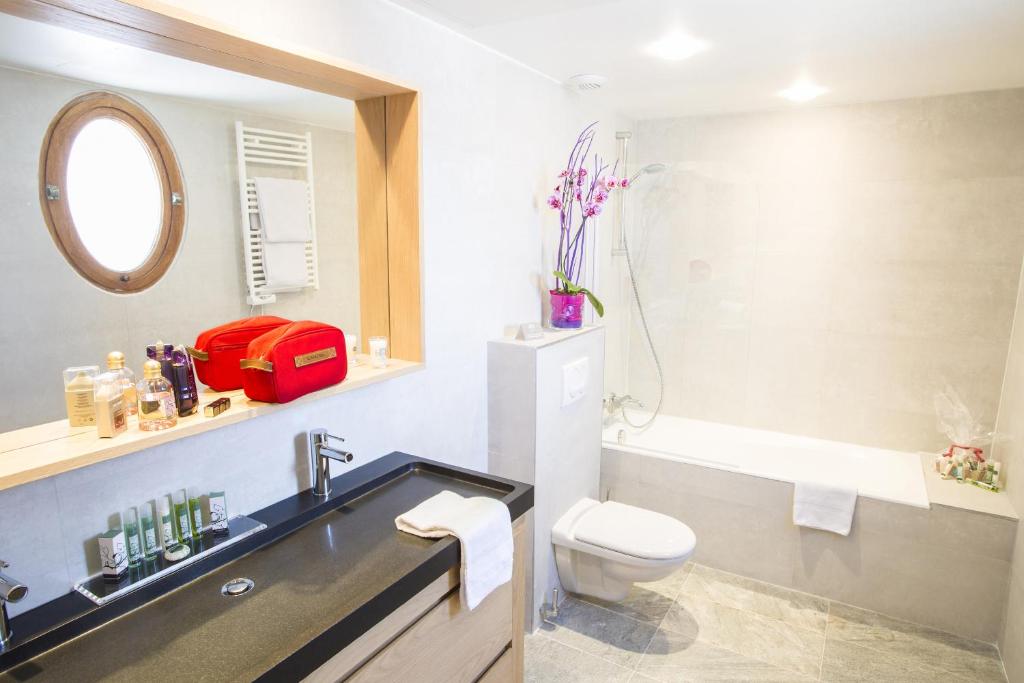 a bathroom with a sink and a toilet and a mirror at Cristal Hôtel & Spa in Cannes