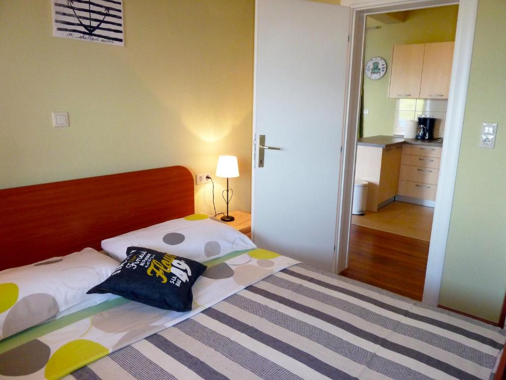 una camera da letto con un letto con un cuscino sopra di Apartments Tamaris a Trogir