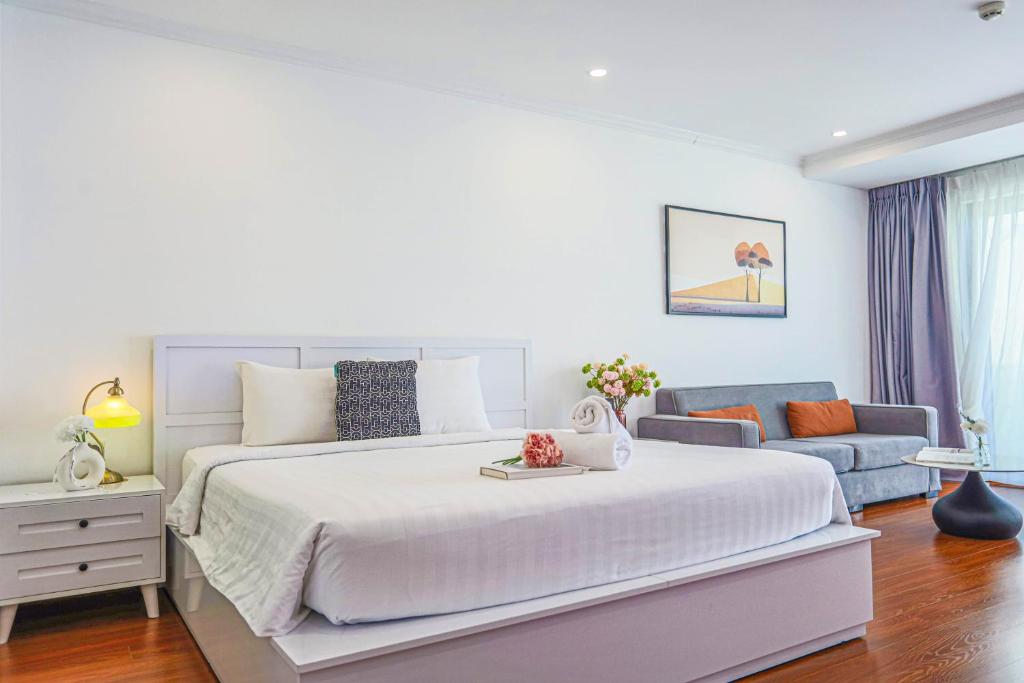 a white bedroom with a large bed and a couch at La Casa Nha Trang - GoldCoast Tower, Yellow-Amber-Beach & Lotte Mall in Nha Trang