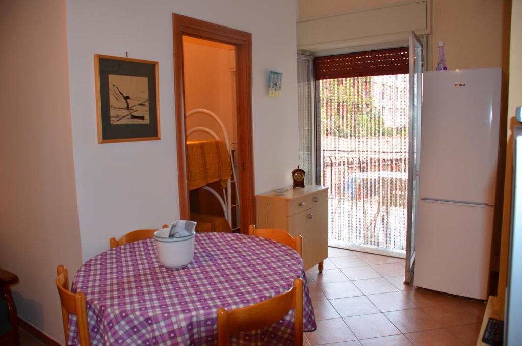 una cucina con tavolo e frigorifero di Appartamento Giardini Naxos a Giardini Naxos