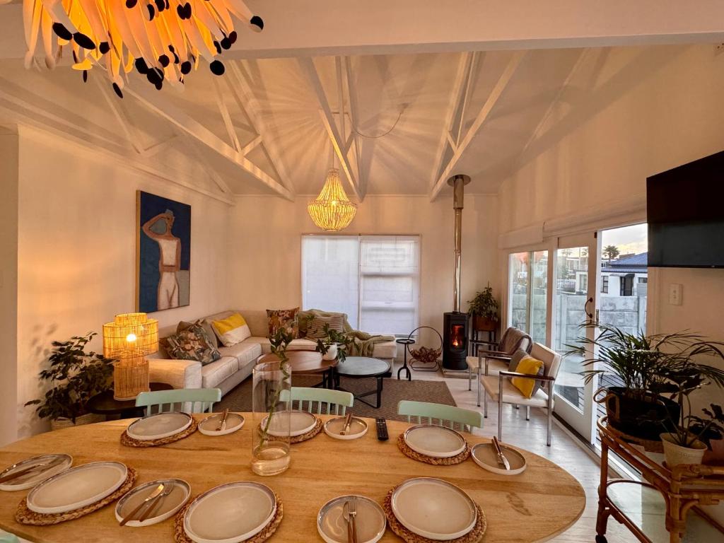 a living room with a table with plates on it at Beach House by Beach Collection Winelands in Strand