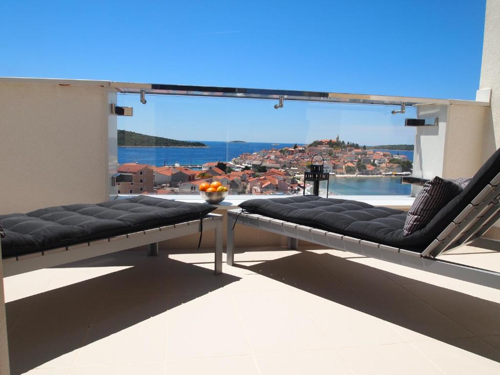 a balcony with two chairs and a view of the water at Apartments Zorka in Primošten