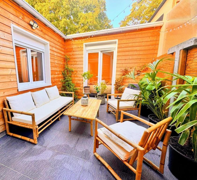 un patio con 2 sedie e un tavolo su una casa di Maison Langevin 2-Bedroom House with Cozy Garden & Patio a Lille