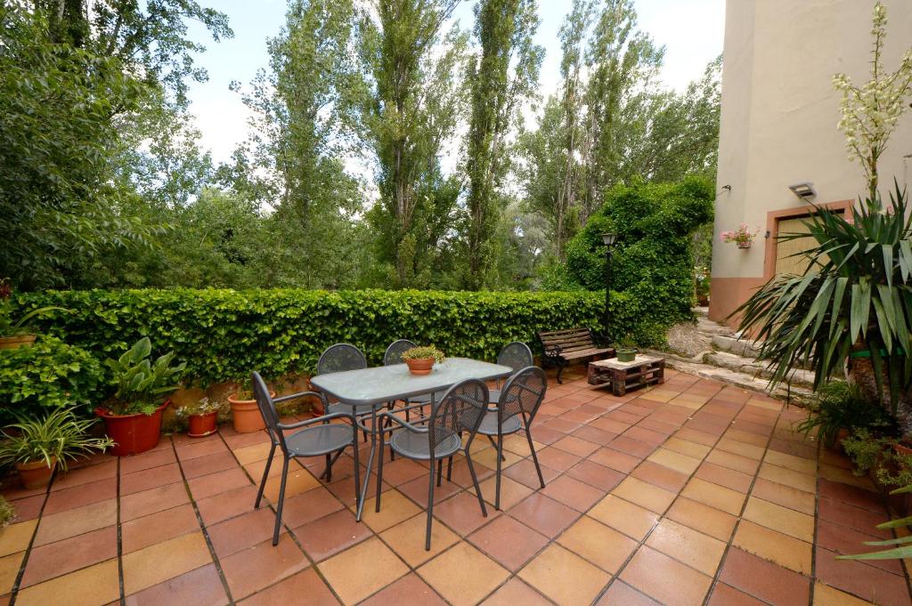 eine Terrasse mit einem Tisch, Stühlen und Pflanzen in der Unterkunft La Riera in Castelserás