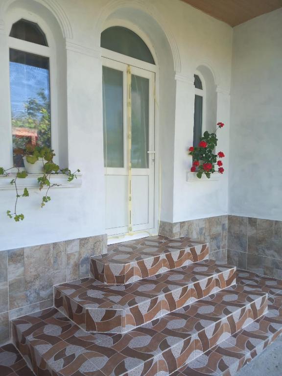 LipniţaにあるCăsuța buniciiの2つの窓の前にレンガの床があるロビー