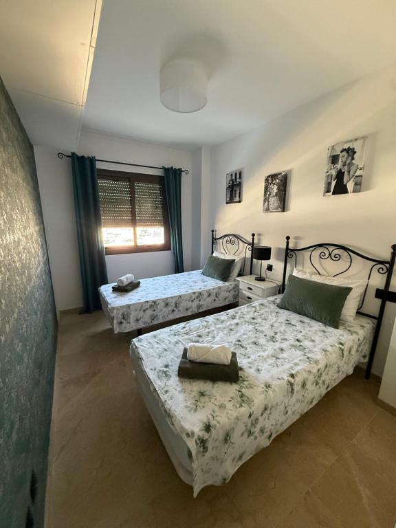 a bedroom with two beds and a window at Puerto Duquesa fancy condo overlooking Marina in Manilva