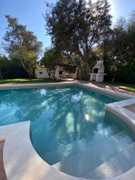una piscina con acqua blu in un cortile di Villa Meigama - Porto Giunco a Notteri