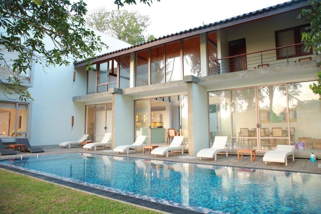 a house with a swimming pool next to a building at ONA Garden Villa in Galgamuwa