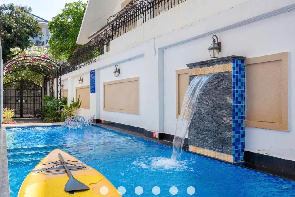 - une piscine avec un kayak en face d'une cascade dans l'établissement Villa Hồ Bơi Trần Văn Thời khu Du Lịch Tháp Tam Thắng, à Vung Tau
