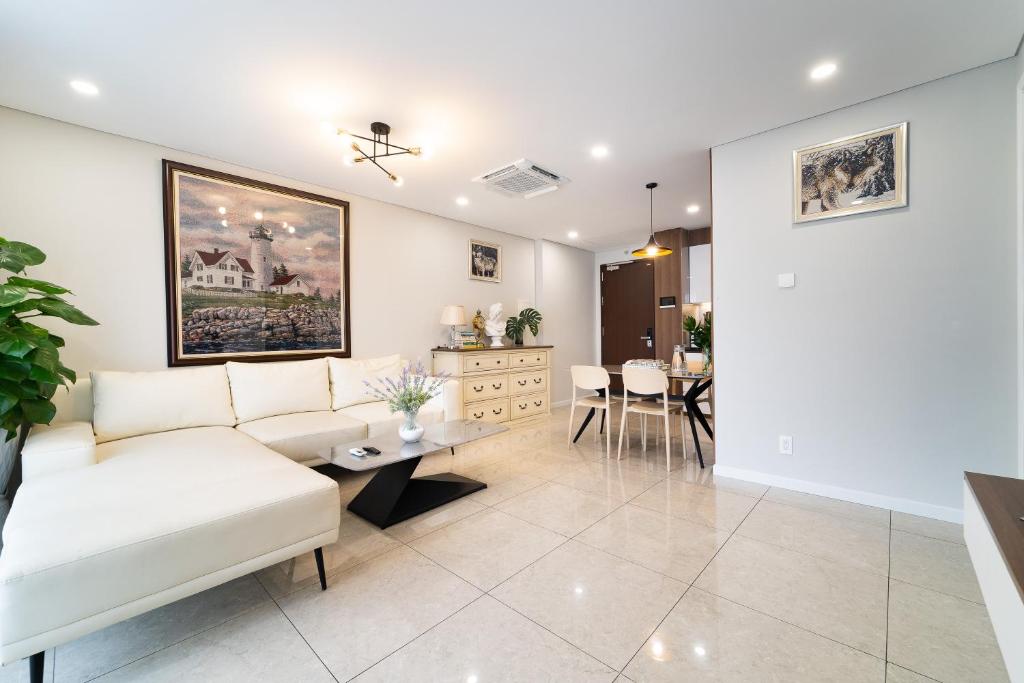 a living room with a white couch and a table at The Silver Vinh Hoi Apartment in Ho Chi Minh City