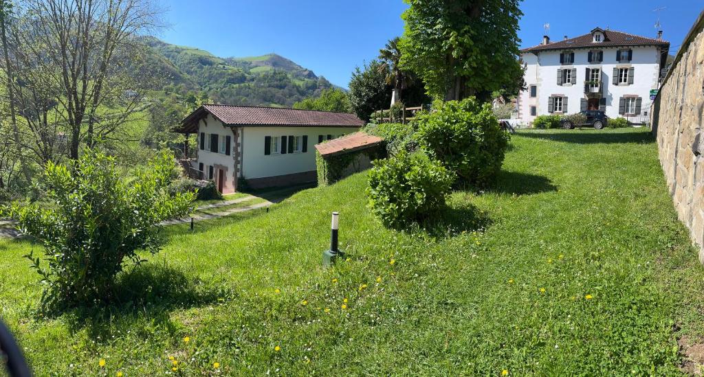 a green yard with a house in the background at Etxezurialde in Valcarlos